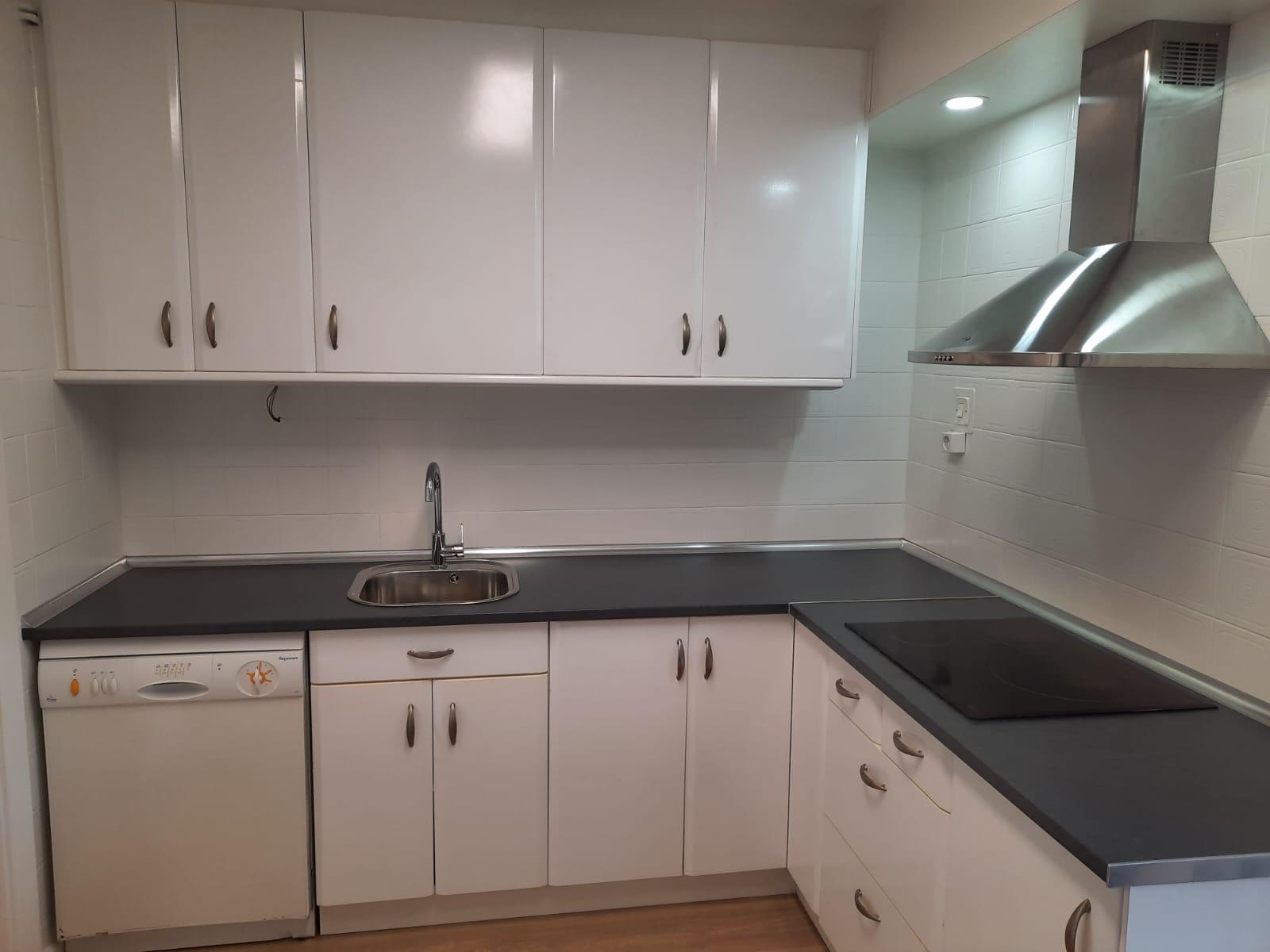 Cocina blanca renovada con encimera oscura