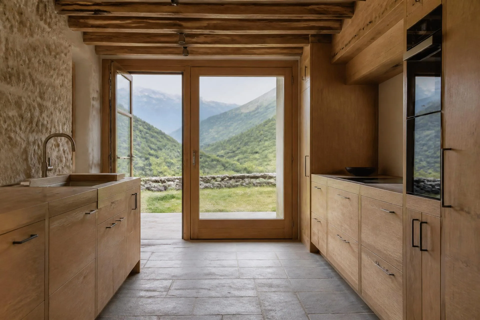 Cocina de madera a medida con vistas a la montaña, obra de Valterra Pirineo