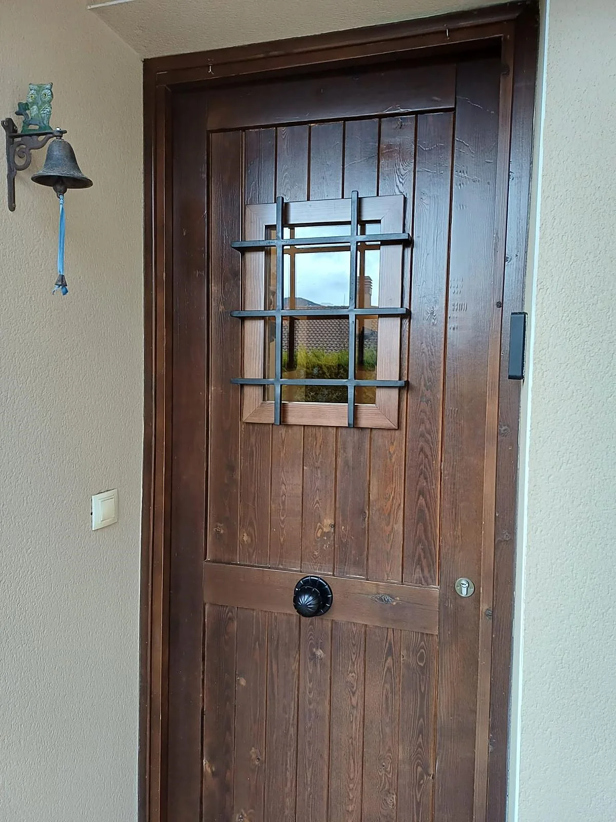 Puerta de entrada de madera maciza con herrajes de forja